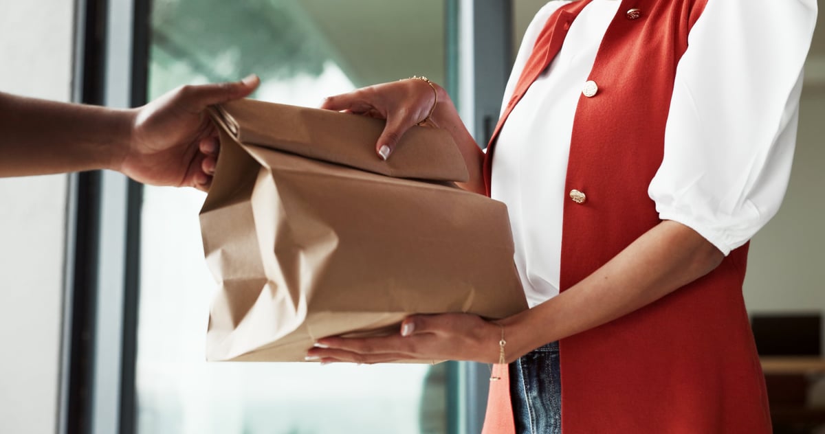 Baked goods handed over in a printed paper bag